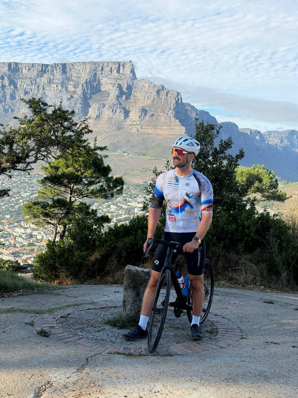 Олег, райд-лидер, с велосипедом на фоне Table Mountain